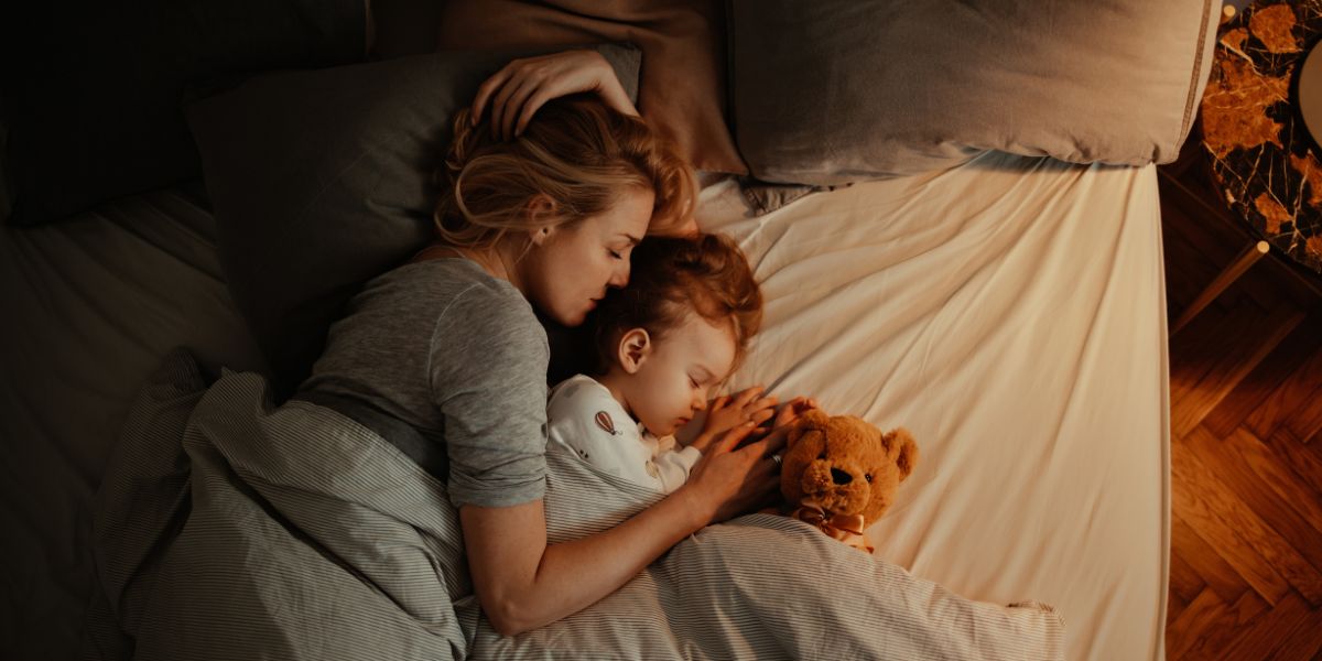 Baby sharing bed top with parents